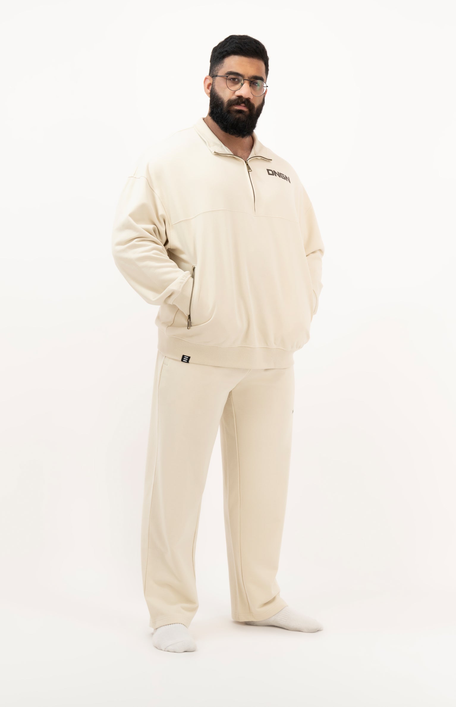 Man wearing a beige tracksuit on a white background