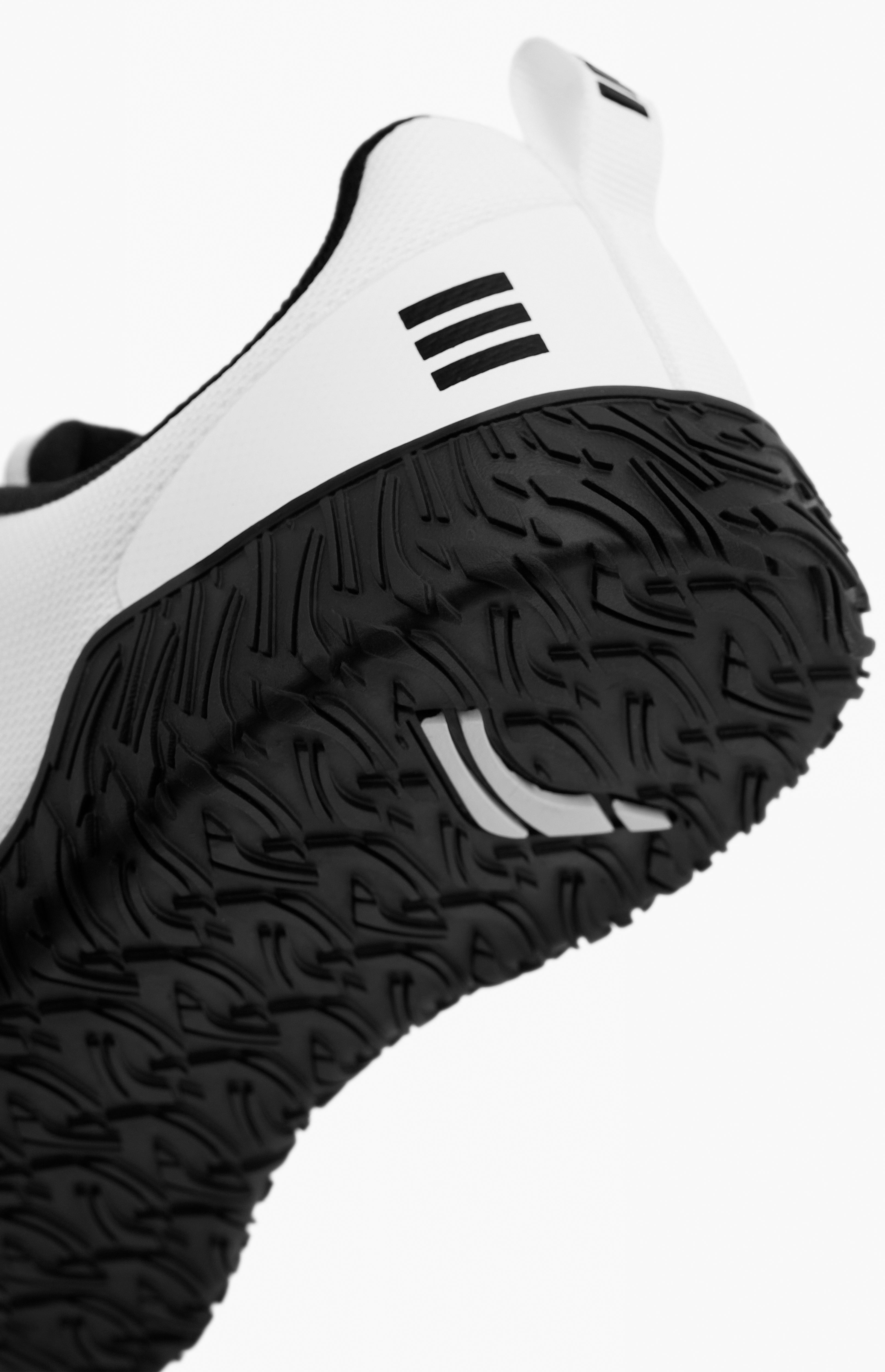 Close-up of a white athletic shoe with black sole on a white background