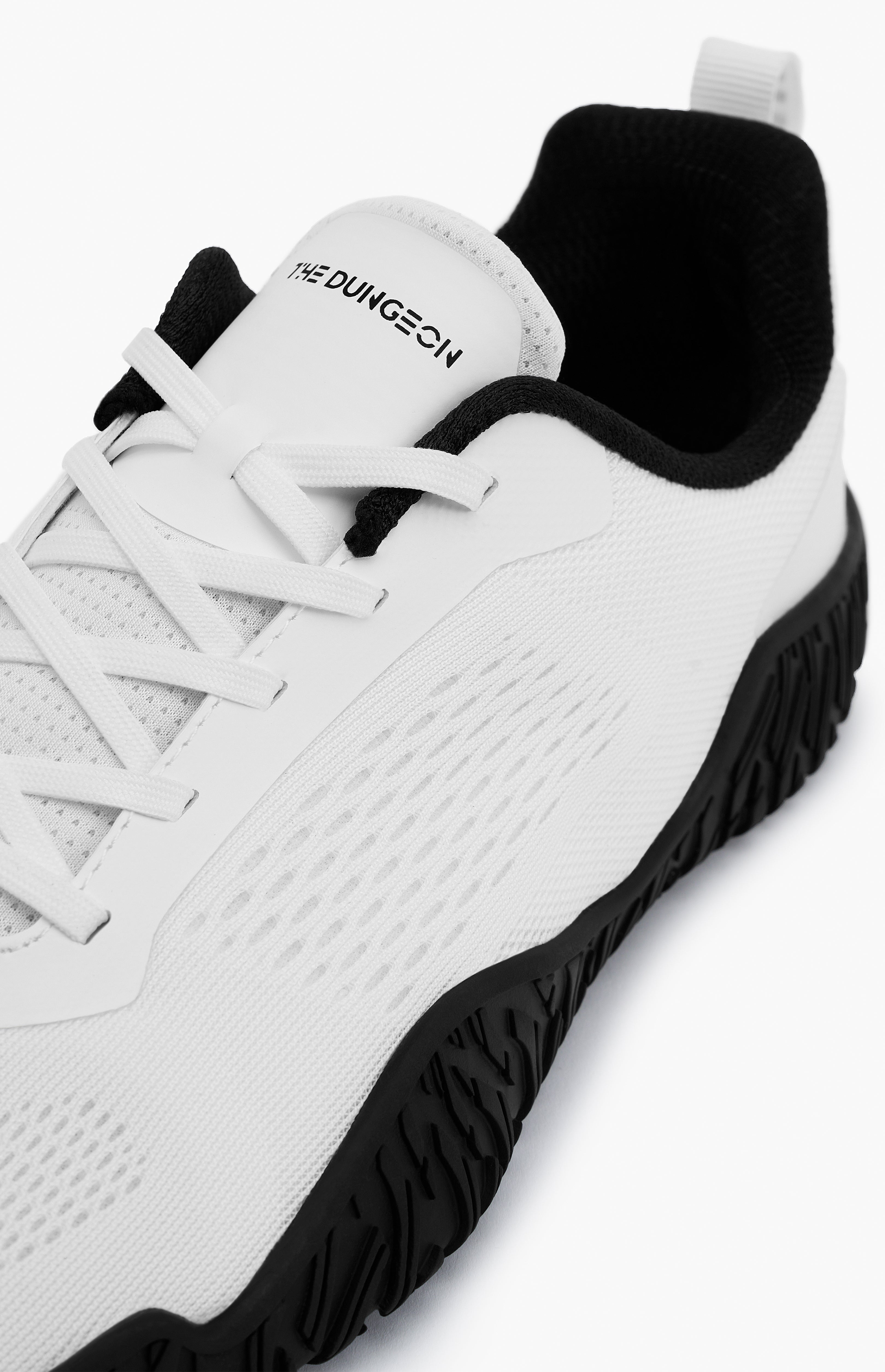 White sneaker with black sole on a white background